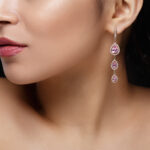 long earring with violet precious stones hang from woman's ear